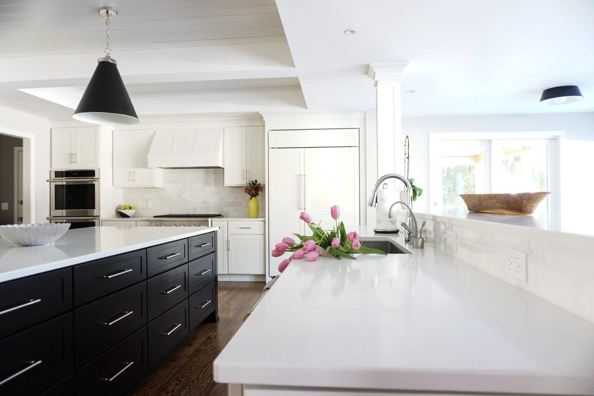 a kitchen with black cabinets and white counter tops