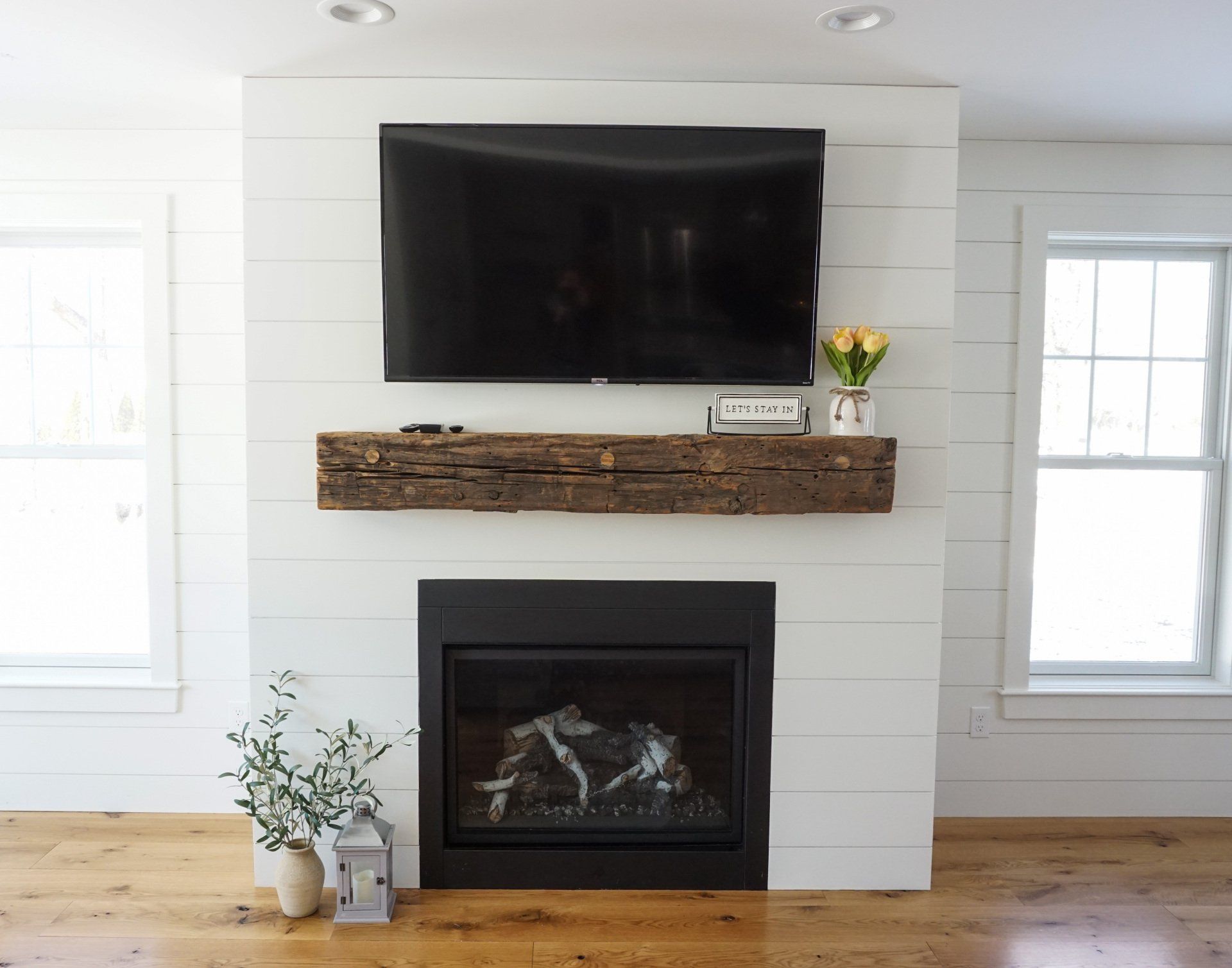 farmhouse addition with shiplap fireplace, fireplace insert, mounted TV and reclaimed wood mantle 