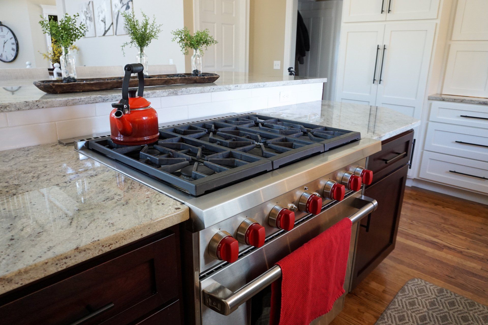 modern kitchen renovation in Hampden County Massachusetts featuring large gas range with red knobs