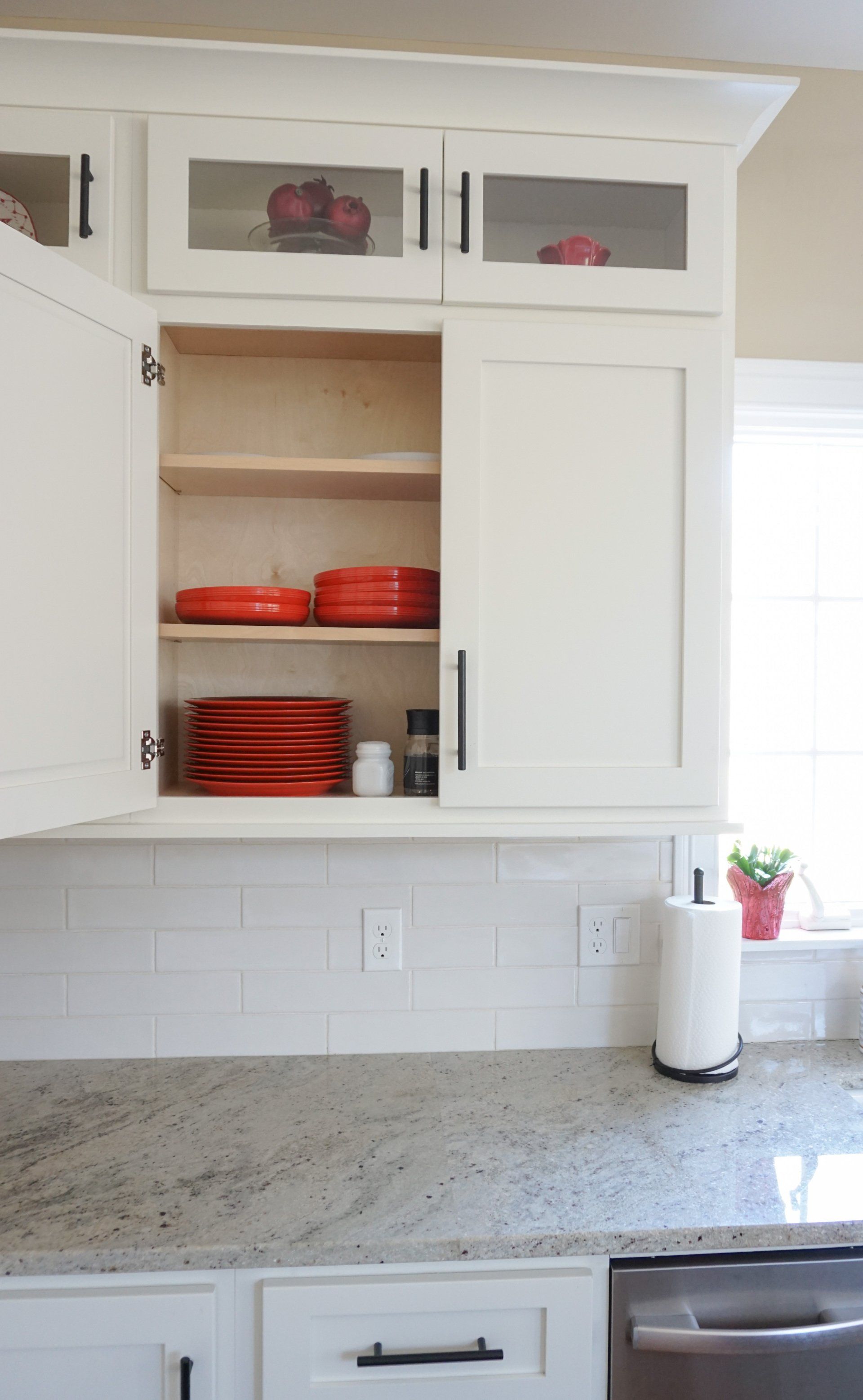 full kitchen renovation. white cabinets with red dishes