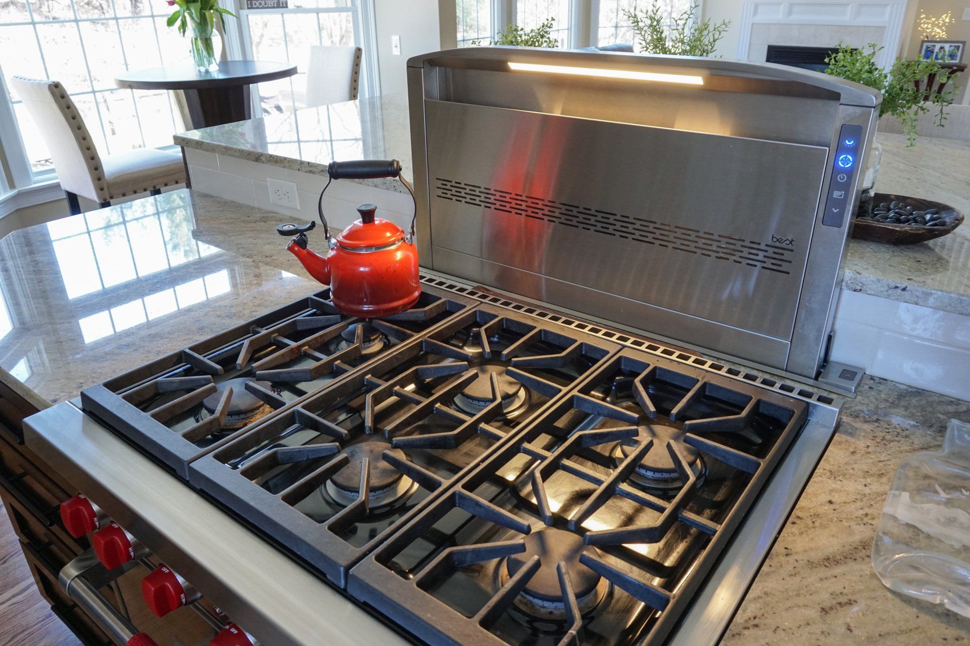 a red tea kettle is sitting on top of a stove with red knobs. New kitchen remodel in Western Mass