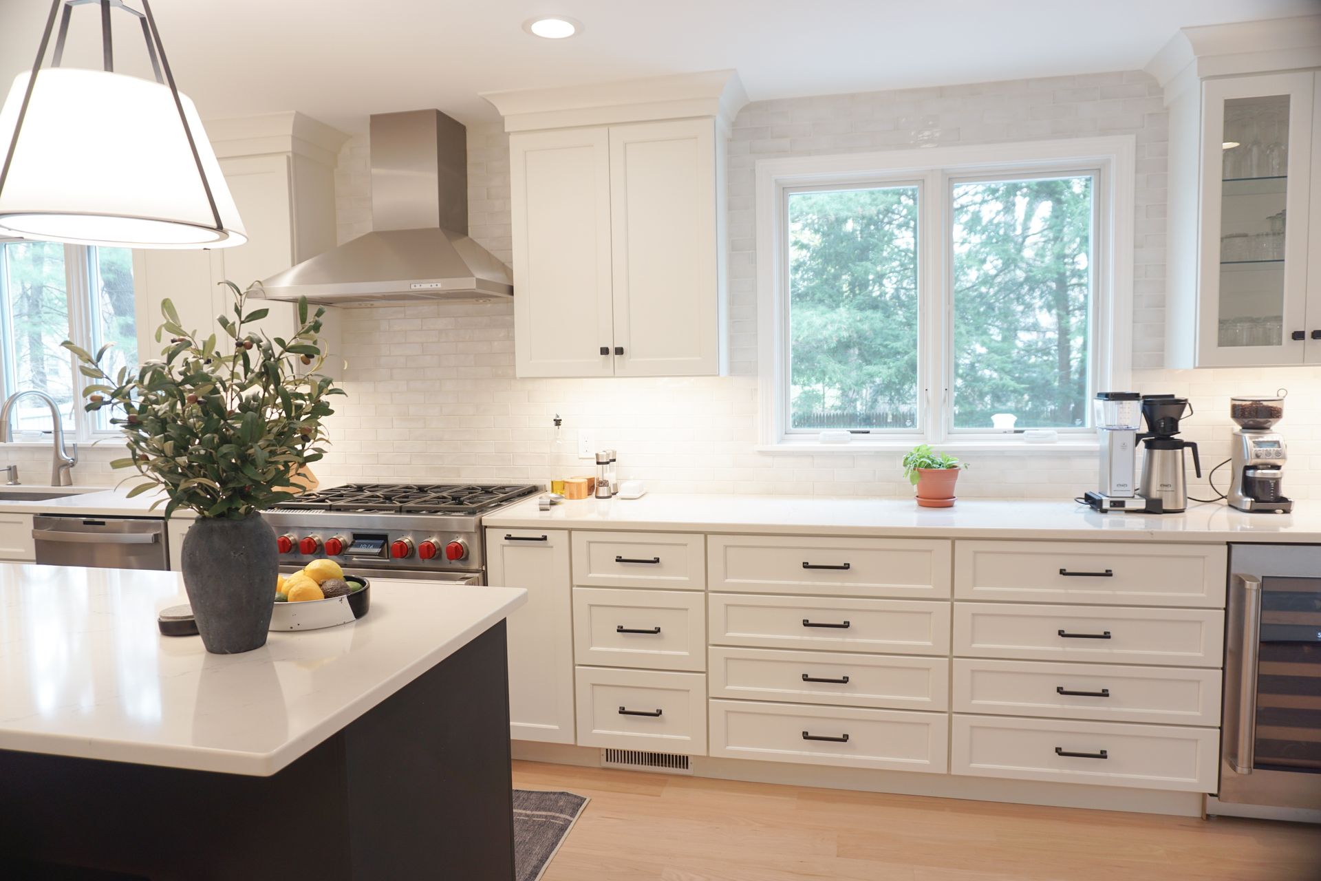 Bright white kitchen with island, stainless range hood, kitchen installation by Chapdelaine Builders in East Longmeadow