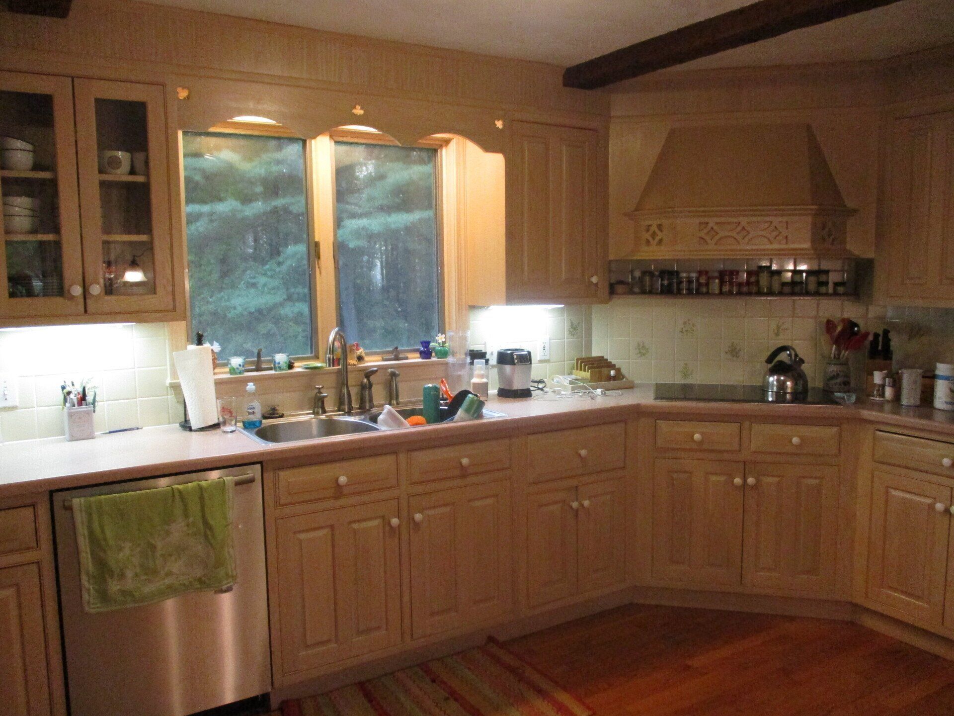 A kitchen with wooden cabinets and a stainless steel dishwasher