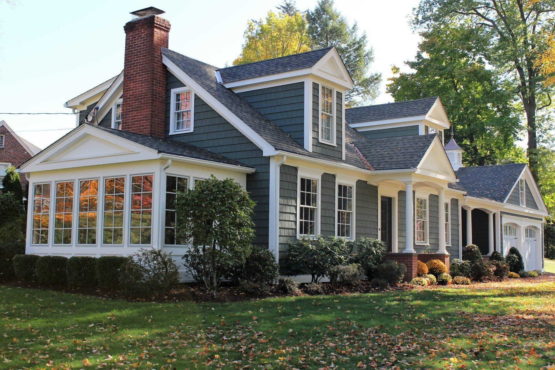 A large house with a gray roof and white trim