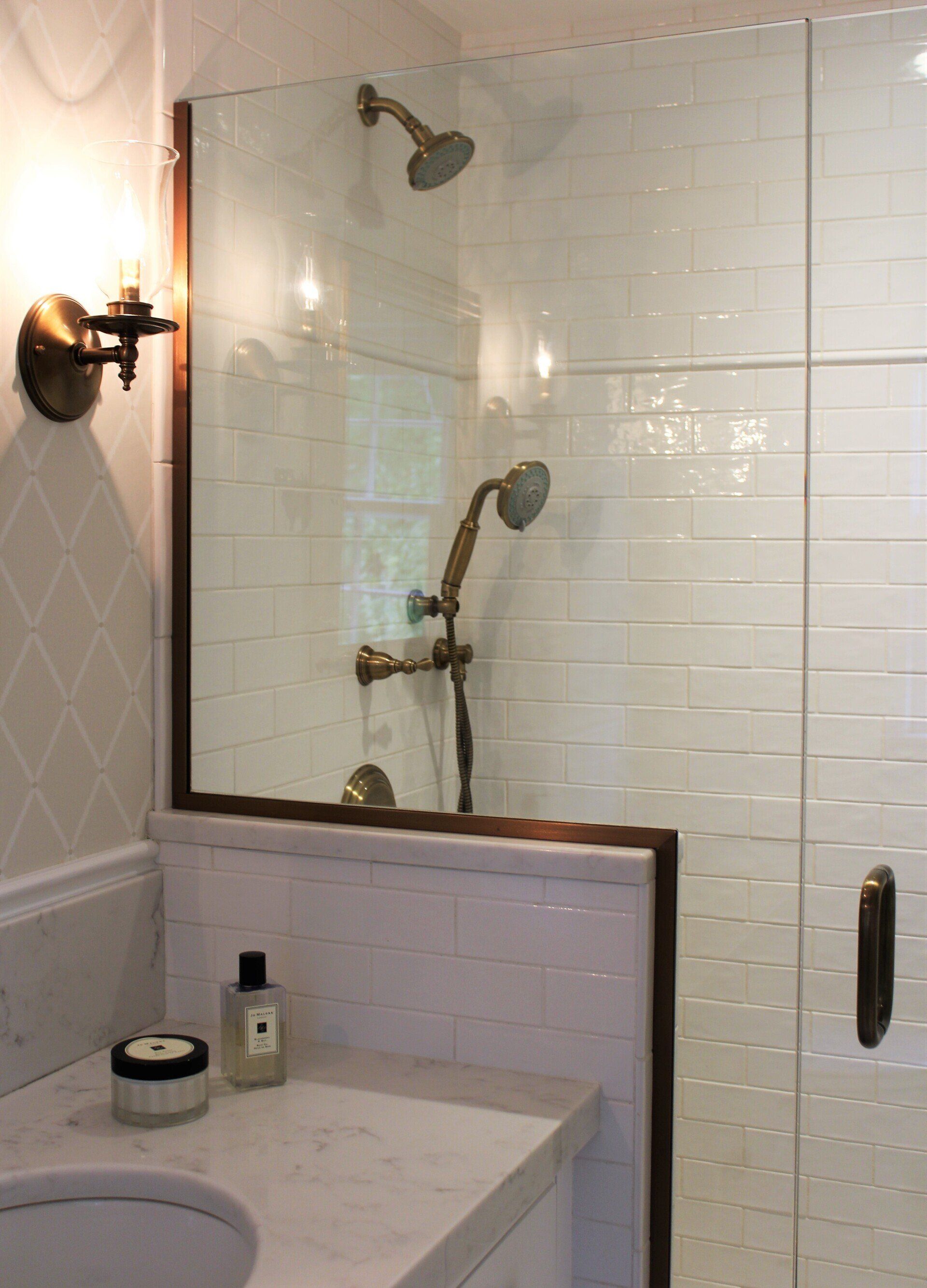beautiful bathroom renovation with half wall in shower with glass