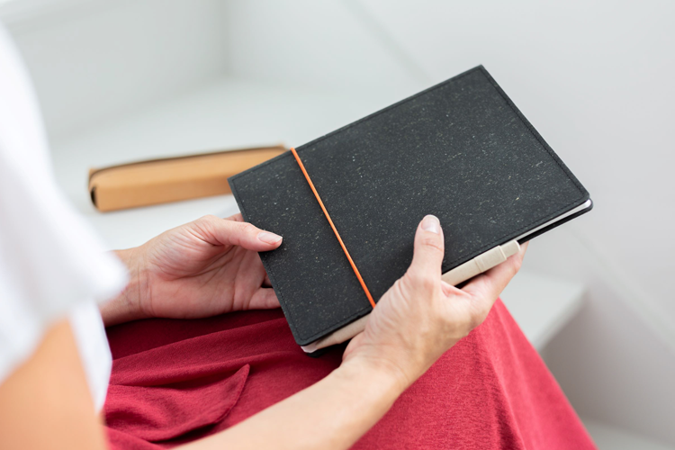 een vrouw die een duurzame luxe notebook vasthoud