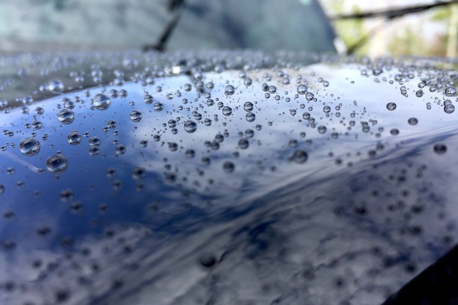 A close up of a car with water drops on it.