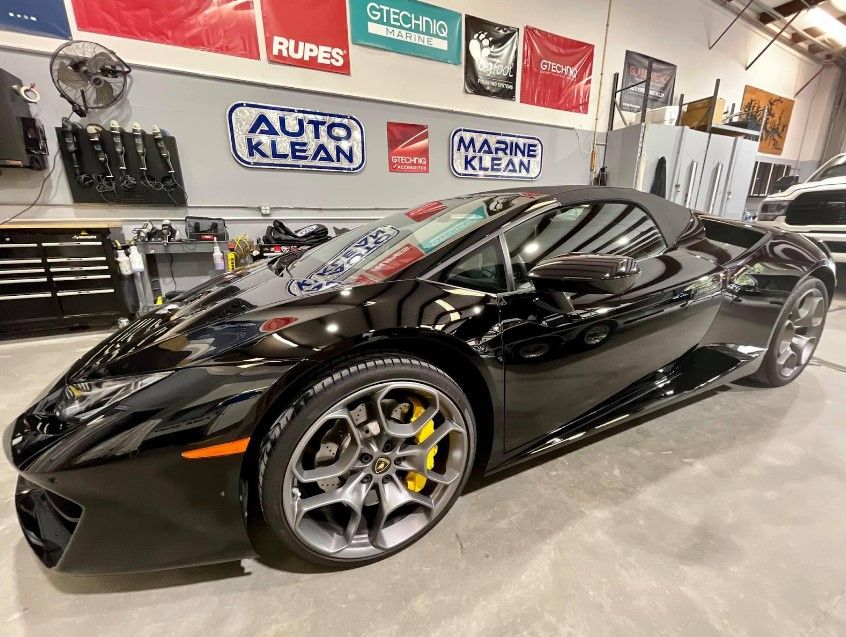 A black lamborghini huracan is parked in a garage.