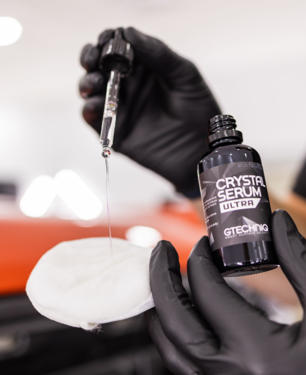 A person is holding a bottle of crystal serum ultra