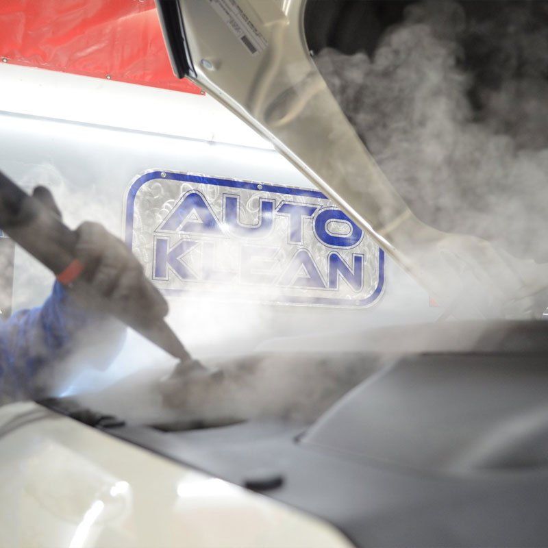 A person is cleaning the hood of a car that says auto clean