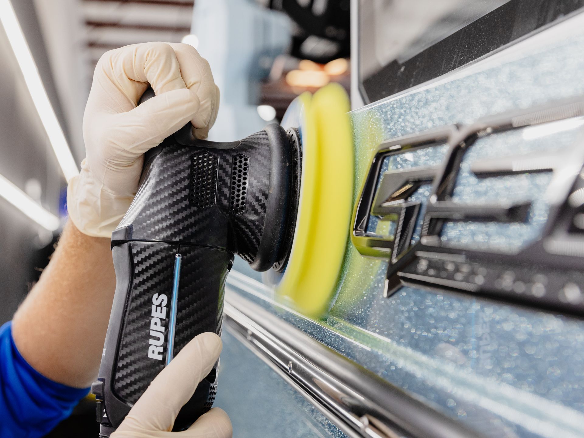A person is polishing a car with a machine.