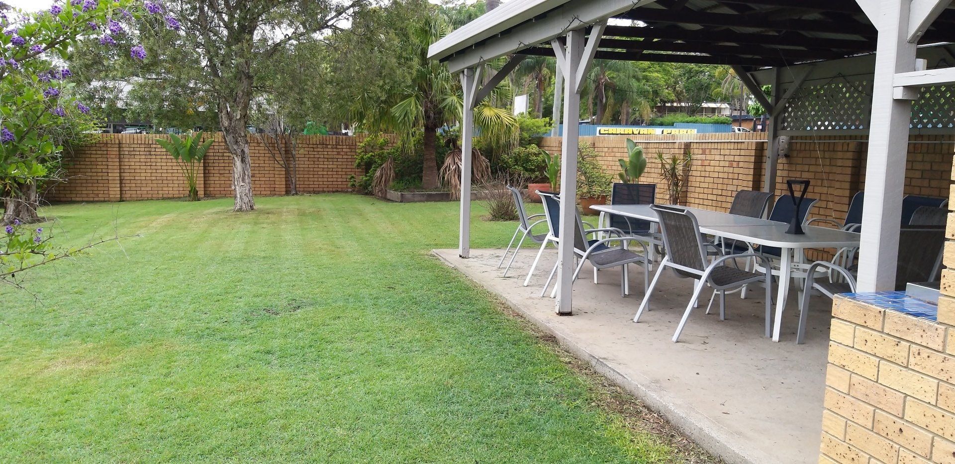 A backyard with a table and chairs under a pergola.