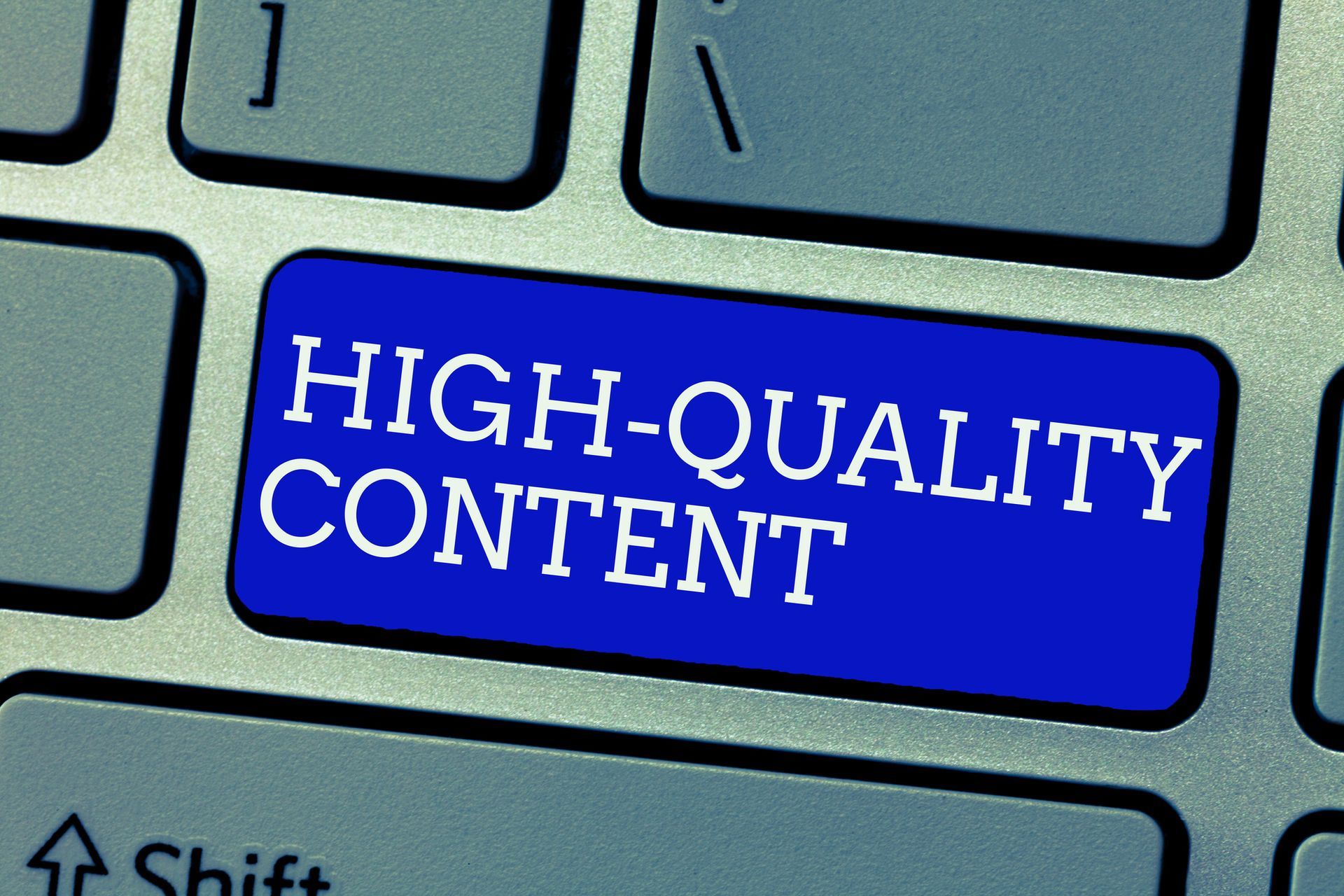 Blue keyboard key labeled “HIGH-QUALITY CONTENT” between gray keys
