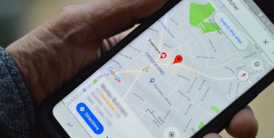 A person is holding a cell phone with a map on it.