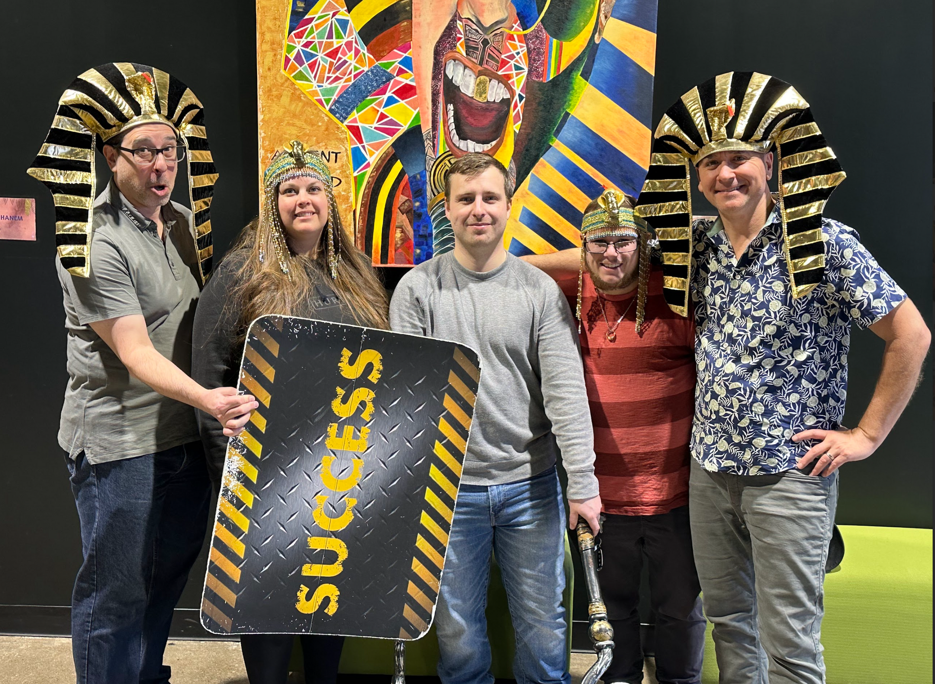 A group of people wearing pharaoh hats and holding a sign that says success.