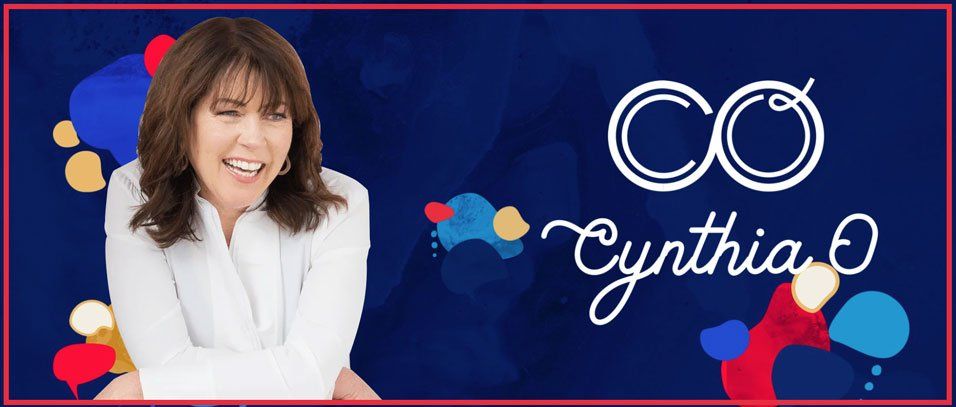 A woman is smiling in front of a blue background with the name cynthia written on it.