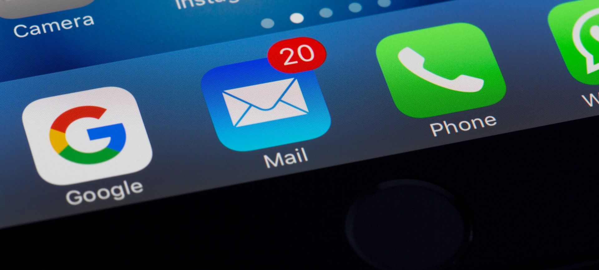 A close up of a cell phone screen with icons for google , mail , and phone.