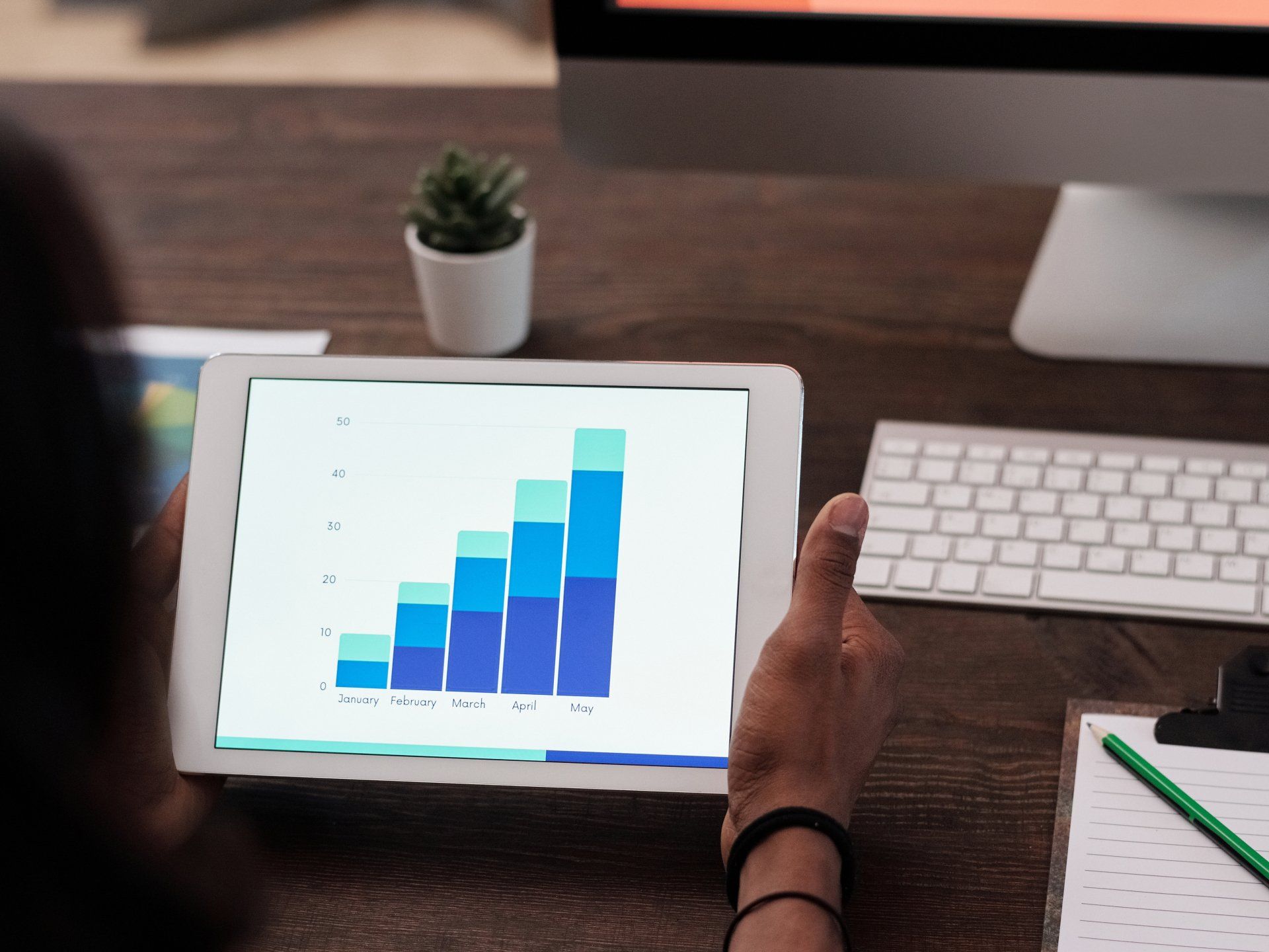 A person is holding a tablet with a graph on it.