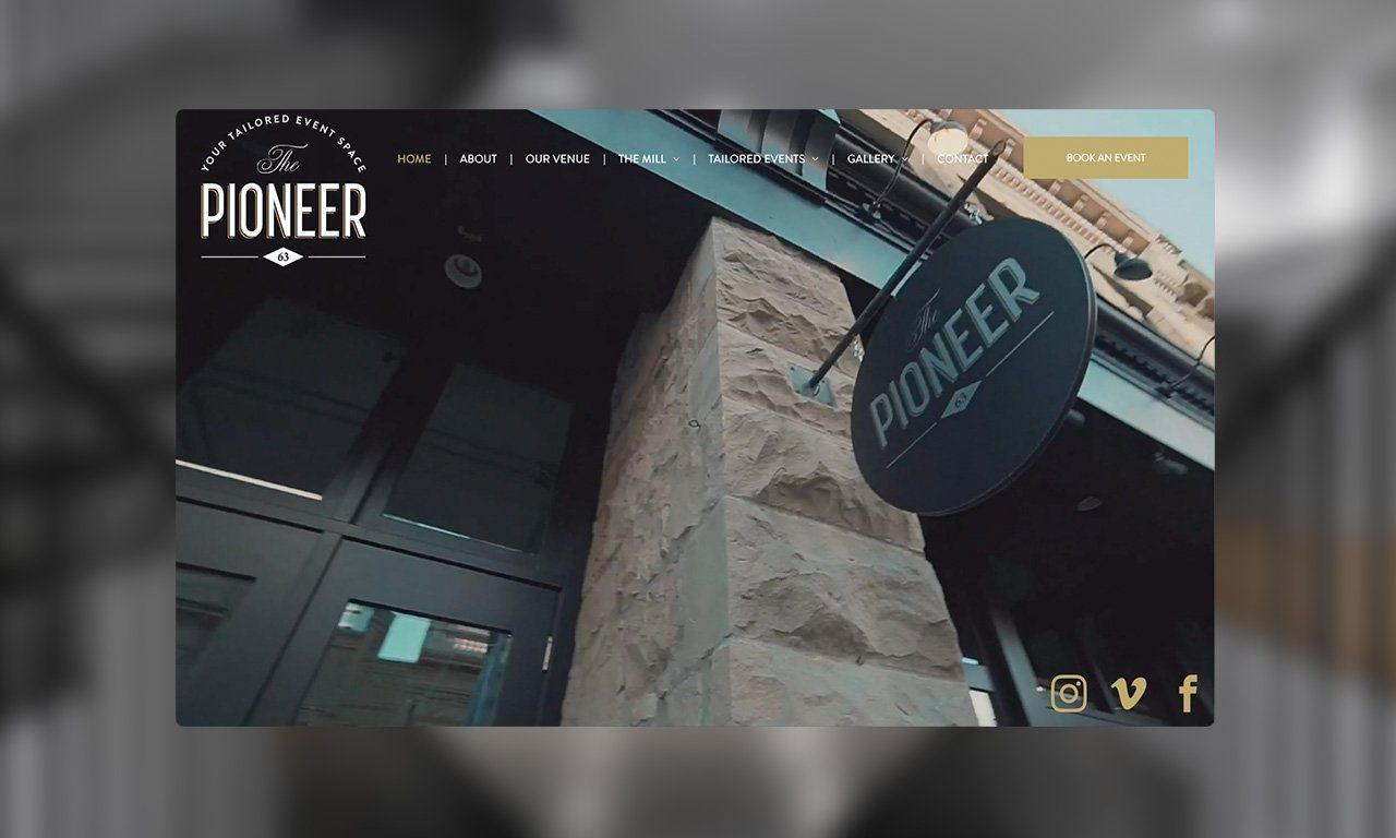 A pioneer sign hangs from the side of a building