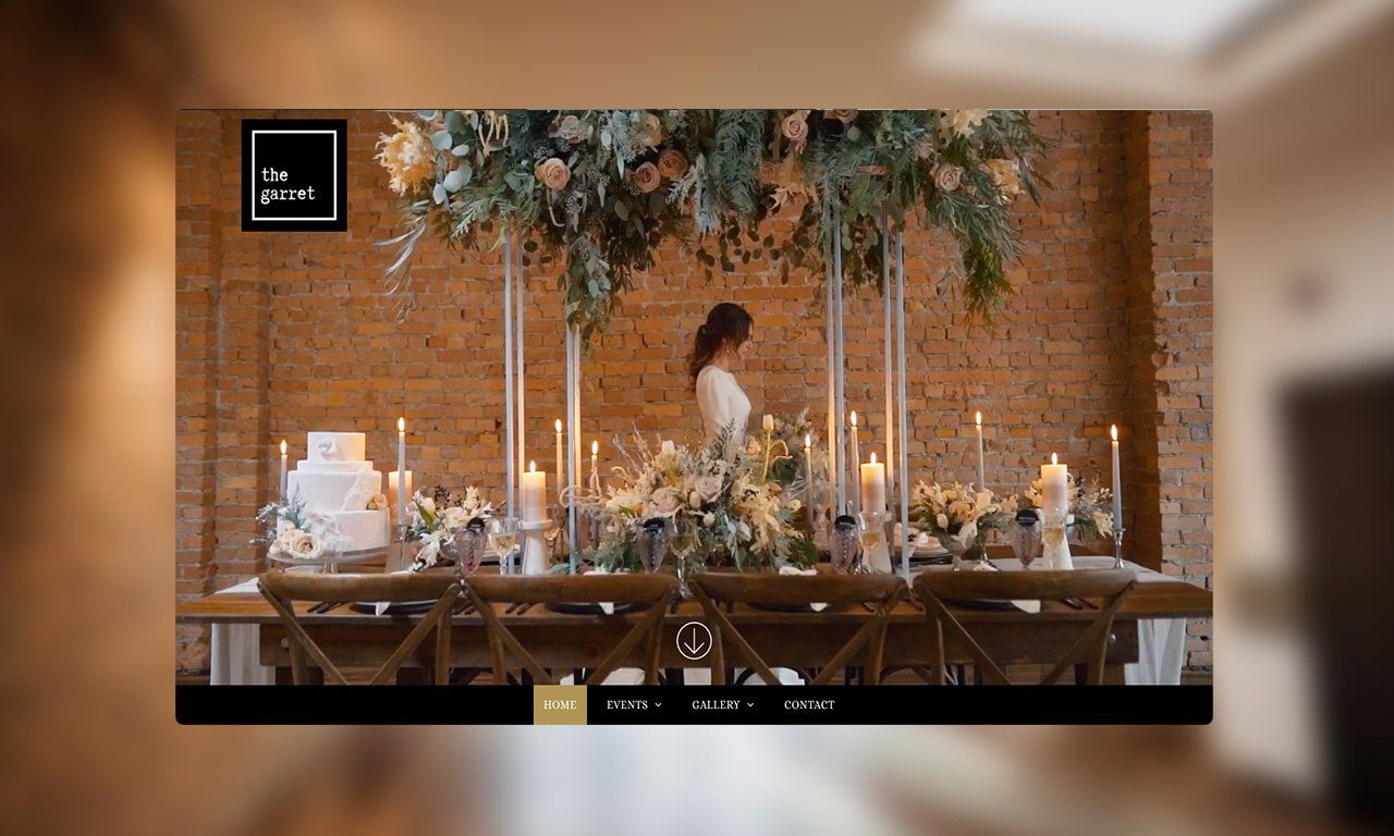 A woman in a white dress is standing in front of a long table with candles and flowers.