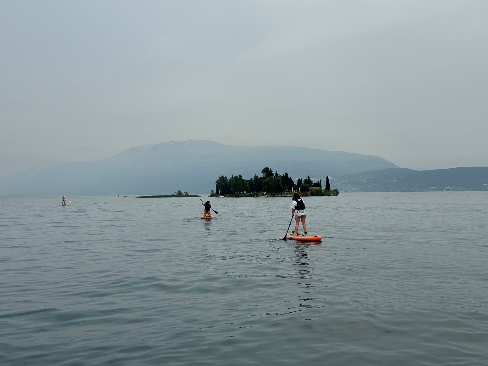 Tour guidato in SUP verso l'Isola dei Conigli con i profili delle montagne sullo sfondo