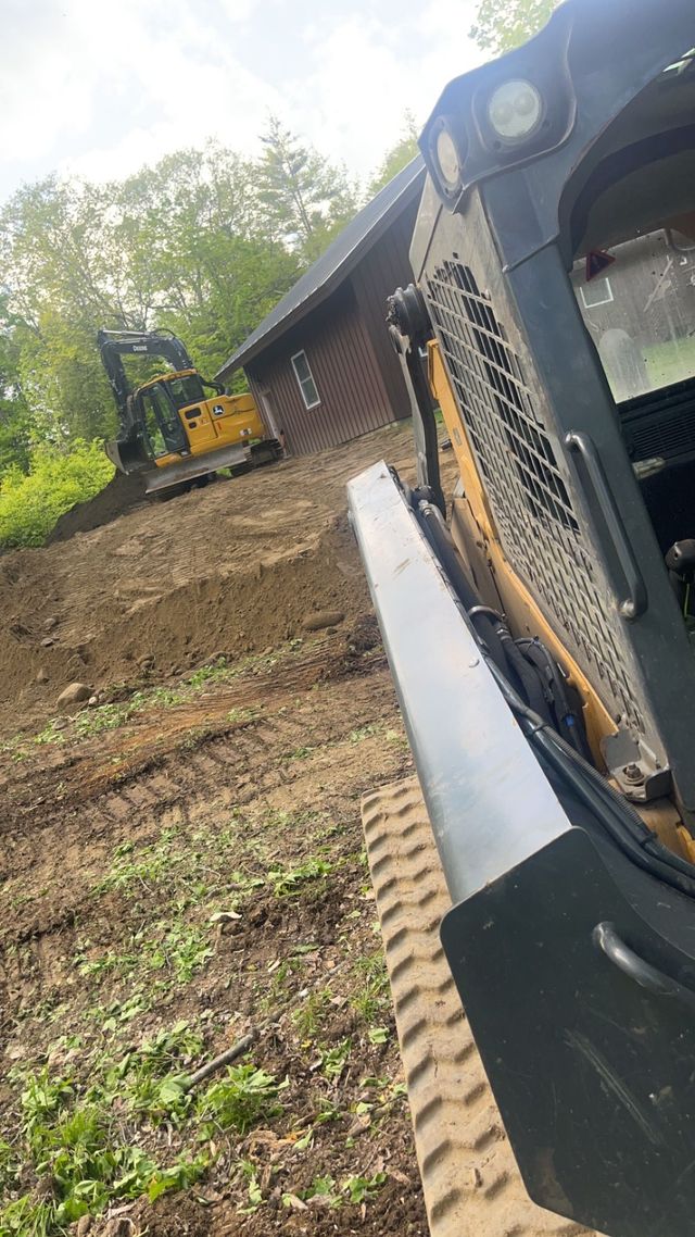 A concrete wall is being built with a bulldozer in the background.