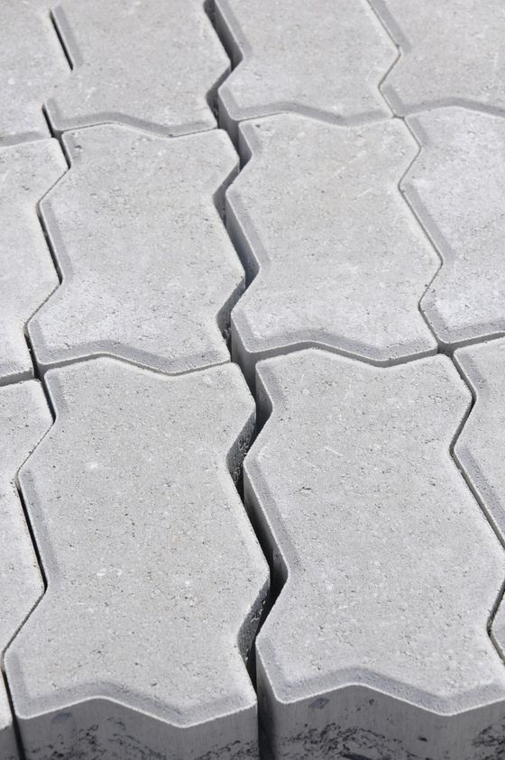 Light gray interlocking concrete pavers in a repeating zigzag pattern