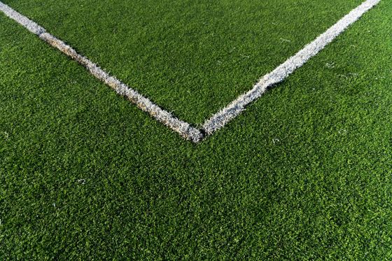 Corner of a soccer field with white boundary lines on green turf