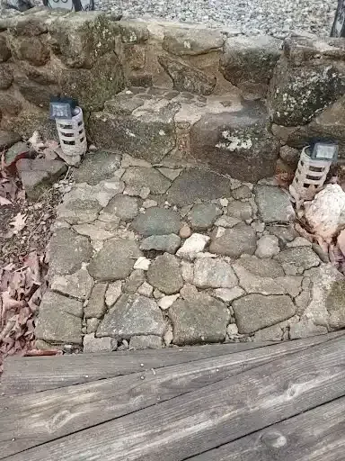 Stone-paved steps and a rocky garden path with two small lanterns on either side