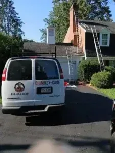 White Chimney Care van parked in a driveway beside a house with a ladder against the roof.