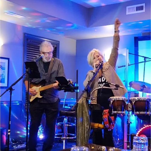 Two Musicians Performing Live Under Blue Lights at Robert A. Lantzy, DMD, LCC in Newtown, PA