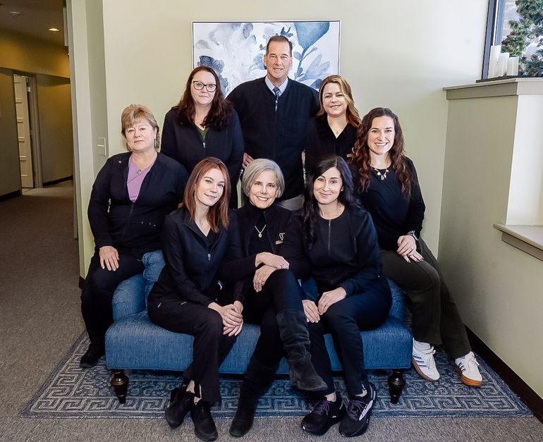 Seven people posing on a blue couch at Robert A. Lantzy, DMD, LCC in Newtown, PA