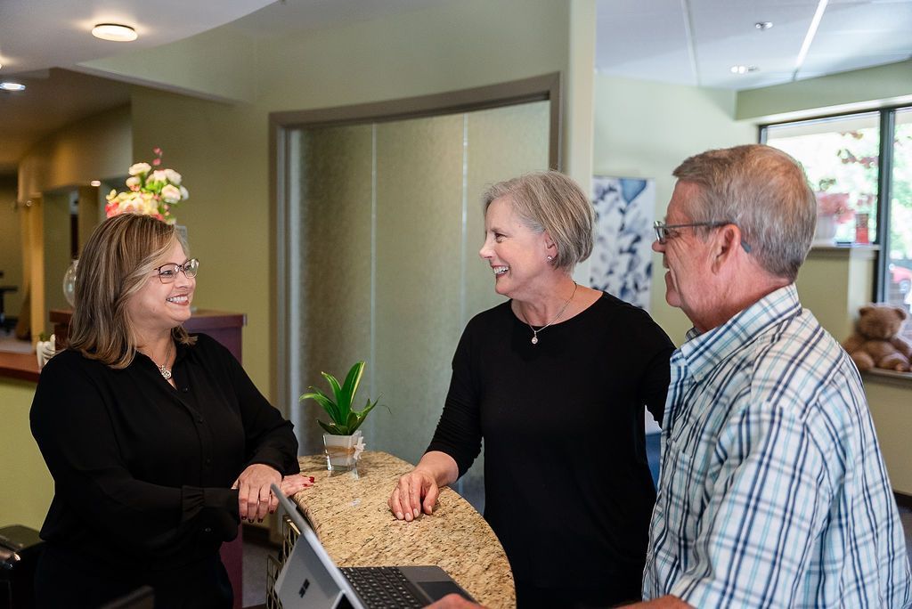 Three people talking at a reception desk at Robert A. Lantzy, DMD, LCC in Newtown, PA