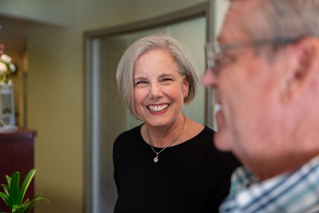 Smiling Marg in black top indoors, with a man at Robert A. Lantzy, DMD, LCC in Newtown, PA