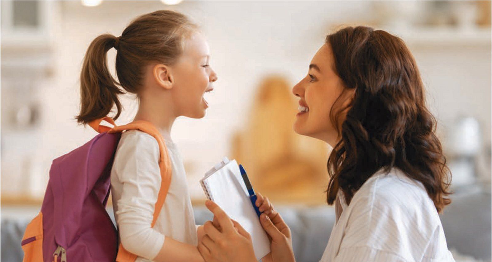 Mother and daughter with a backpack smiling before school, Robert A. Lantzy DMD back-to-school blog
