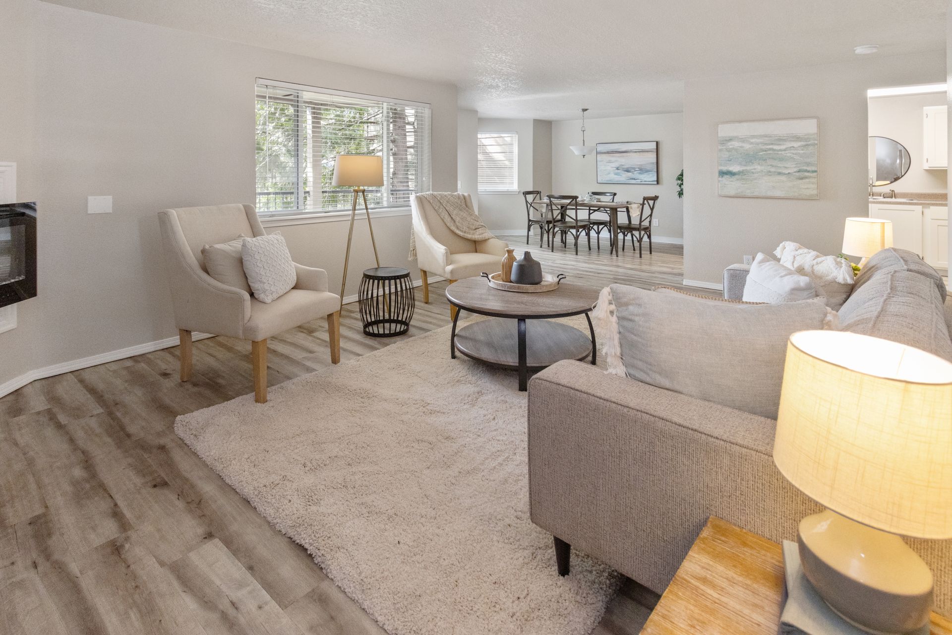 A lounge area with brown leather couches, coffee table, and a pool table in the background.