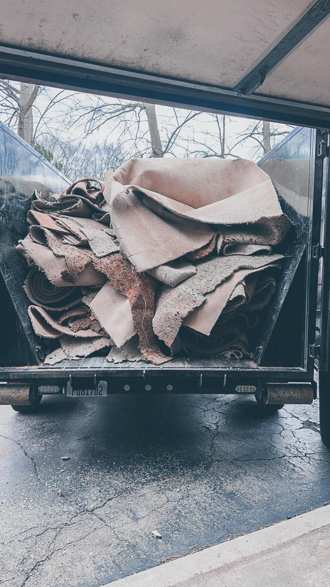 Truck bed loaded with tan cardboard scraps in a rainy outdoor setting