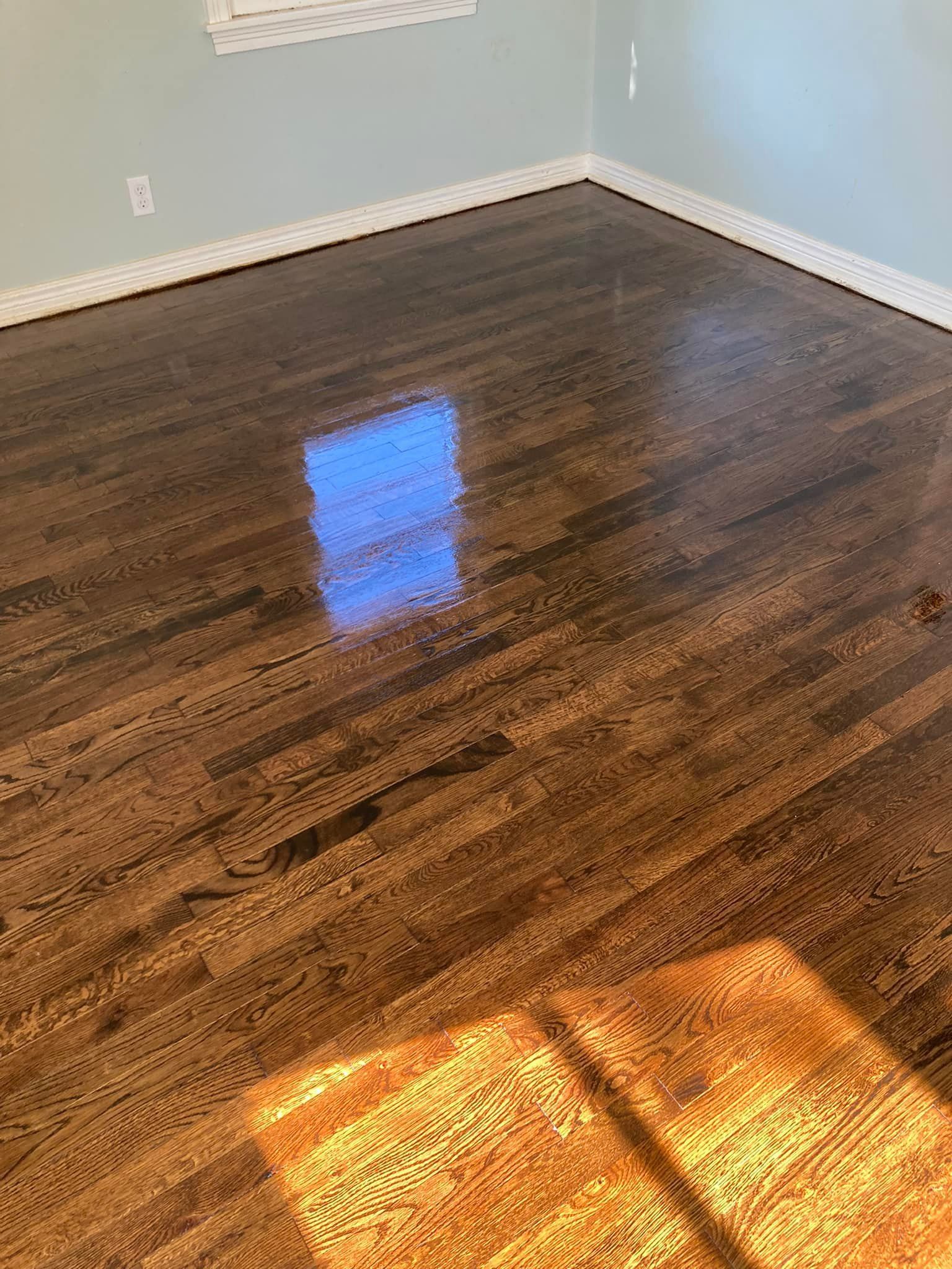 Dark stained hardwood floor with light reflections in a room.
