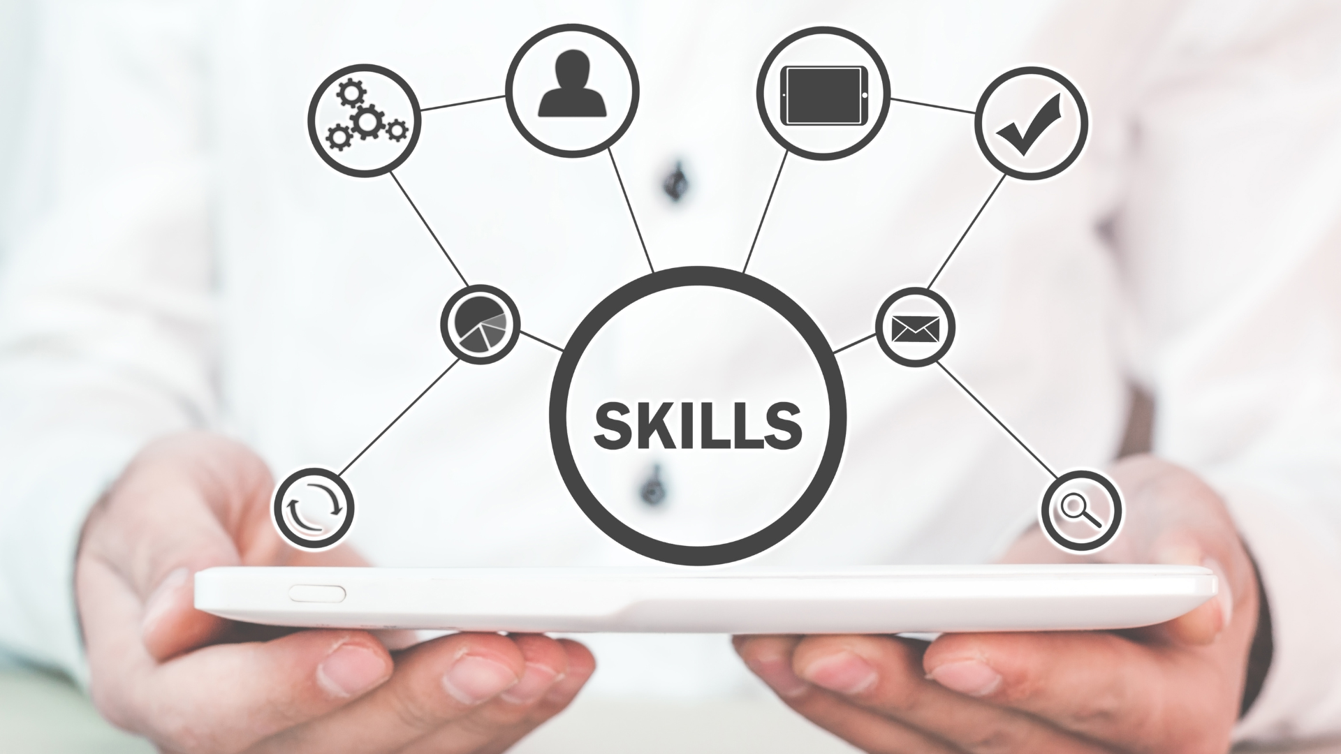 a person holding a tablet with the word skills in the center