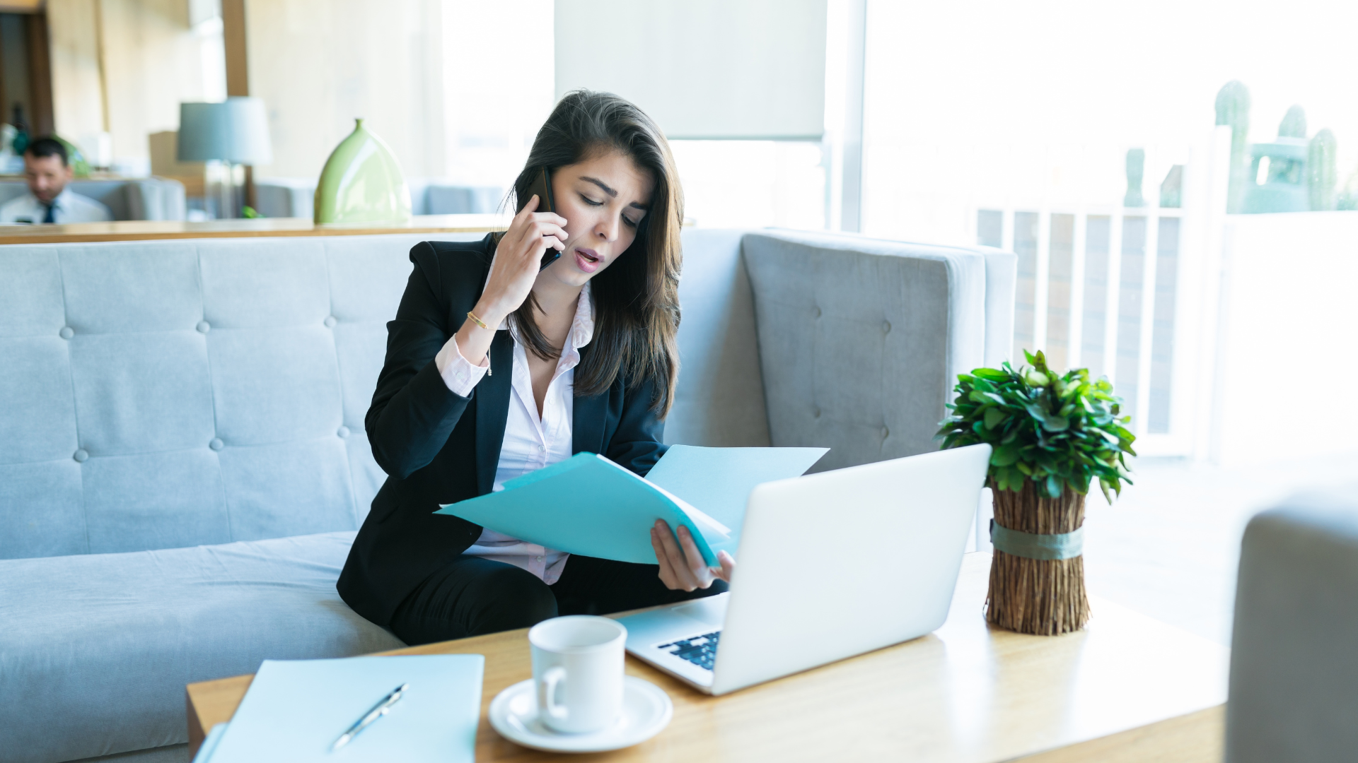 a woman sitting on a couch talking on a cell phone