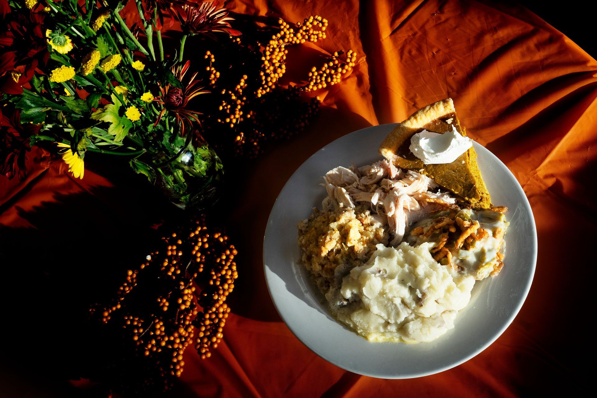 A plate of food on a table with flowers in the background