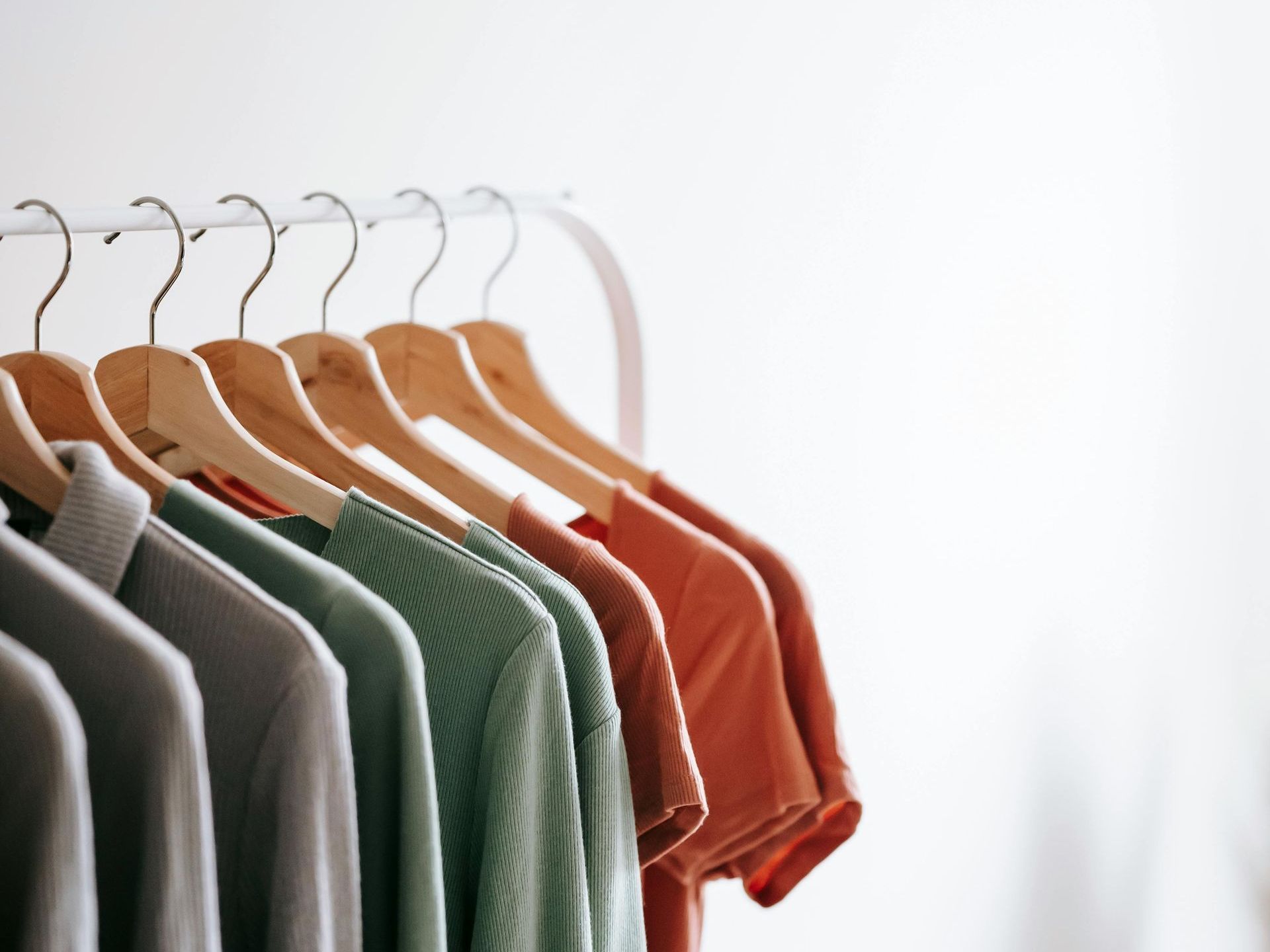 A row of shirts are hanging on a rack.