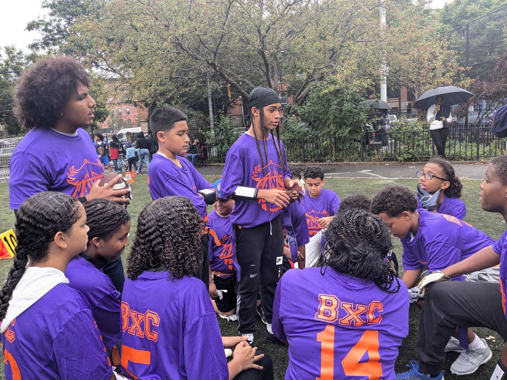 A group of kids wearing purple shirts with the number 14 on them