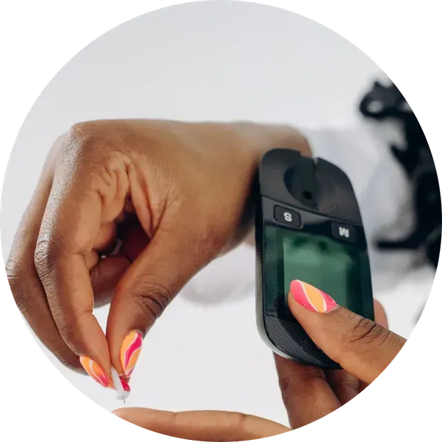 Close-up of hands using a glucose meter to test a fingertip blood sample