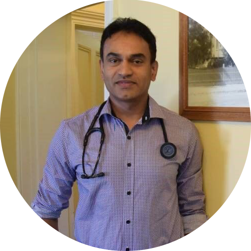 Man standing indoors in a patterned shirt with a stethoscope around his neck