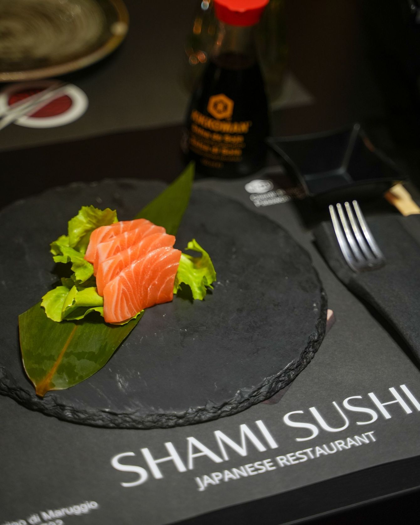 Piatto di sushi con vari involtini, tra cui salmone, cetriolo e semi di sesamo.