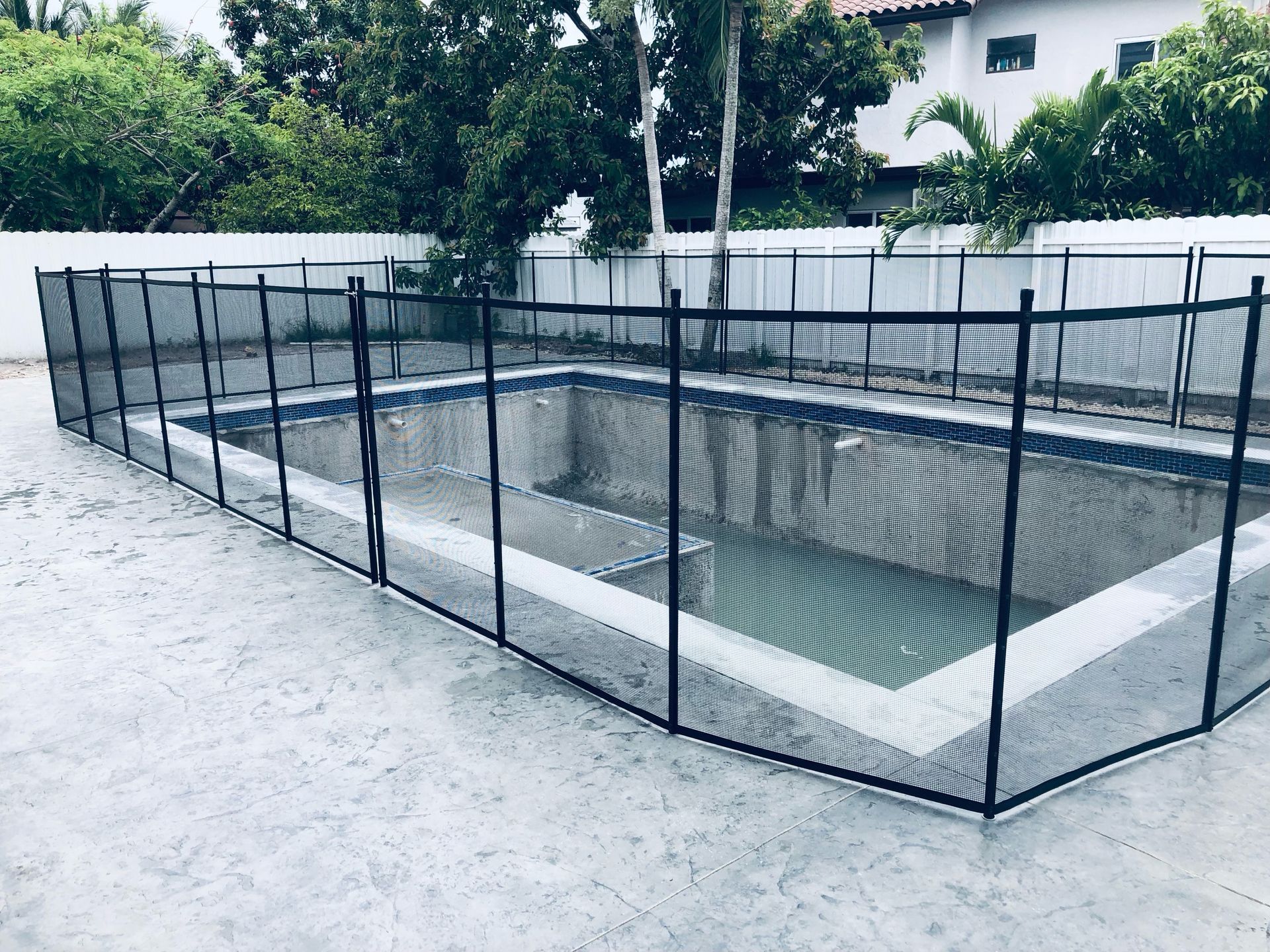 an empty swimming pool with a black fence around it