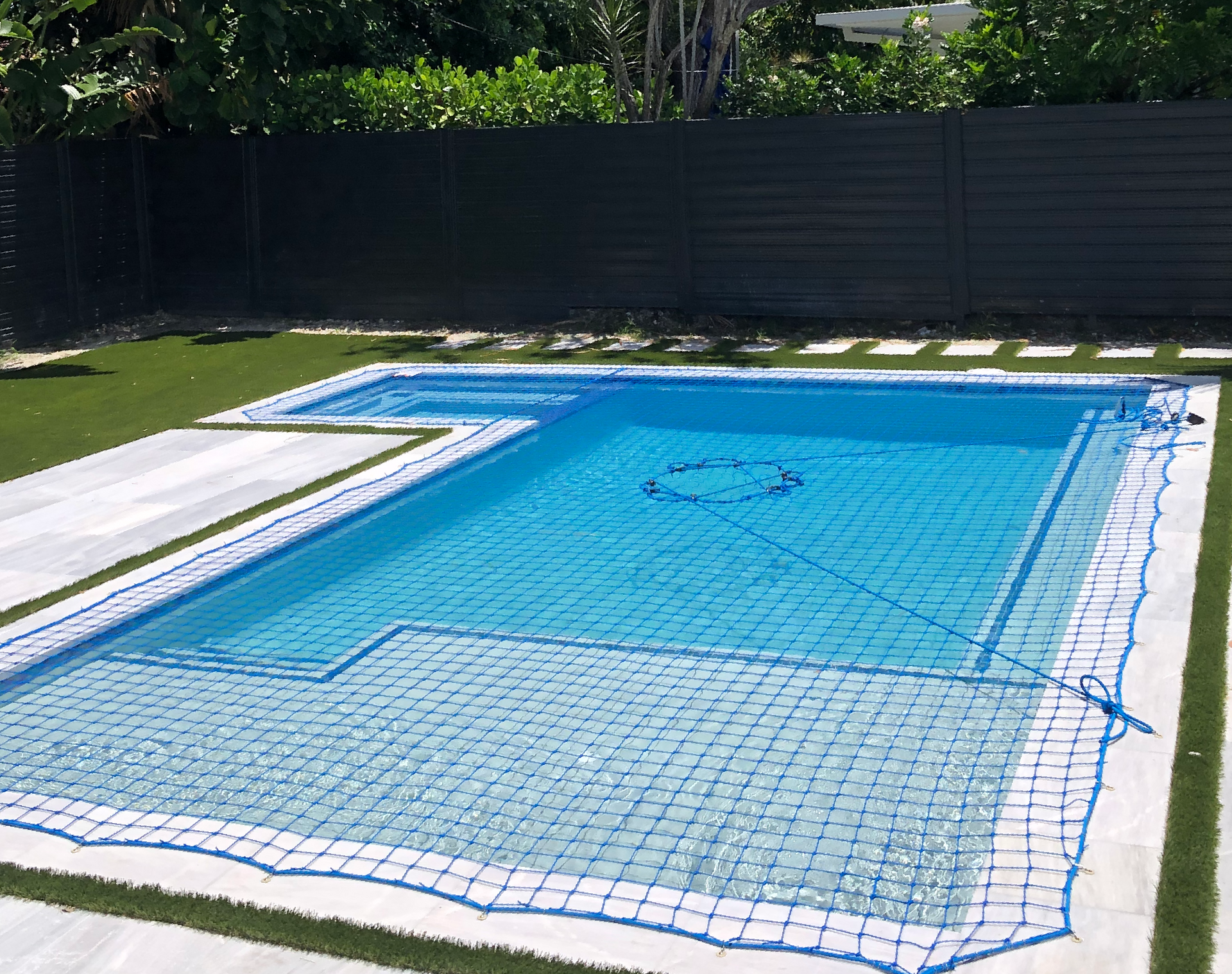a large swimming pool with a blue net around it