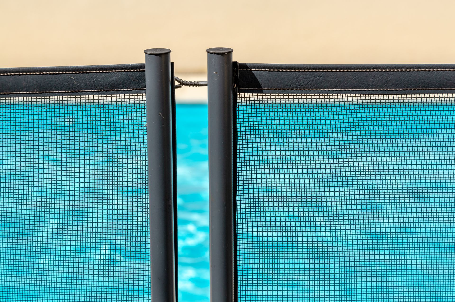 A close up of a fence around a swimming pool.