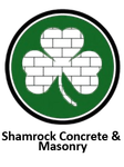 Shamrock Concrete & Masonry logo with green shamrock outlined in black and white brick pattern inside circle